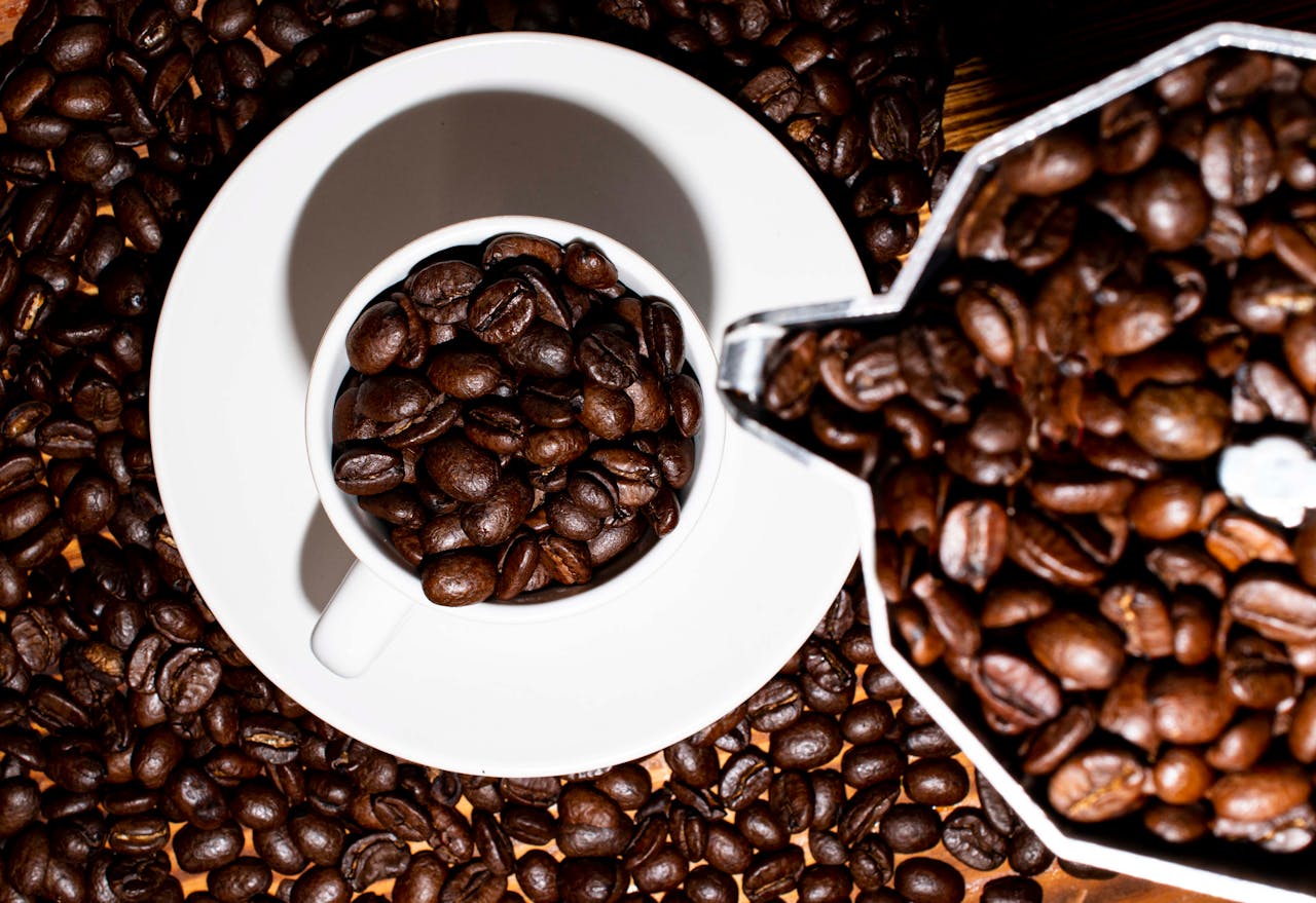 Discover rich coffee aroma with roasted beans in a white cup against a close-up background.